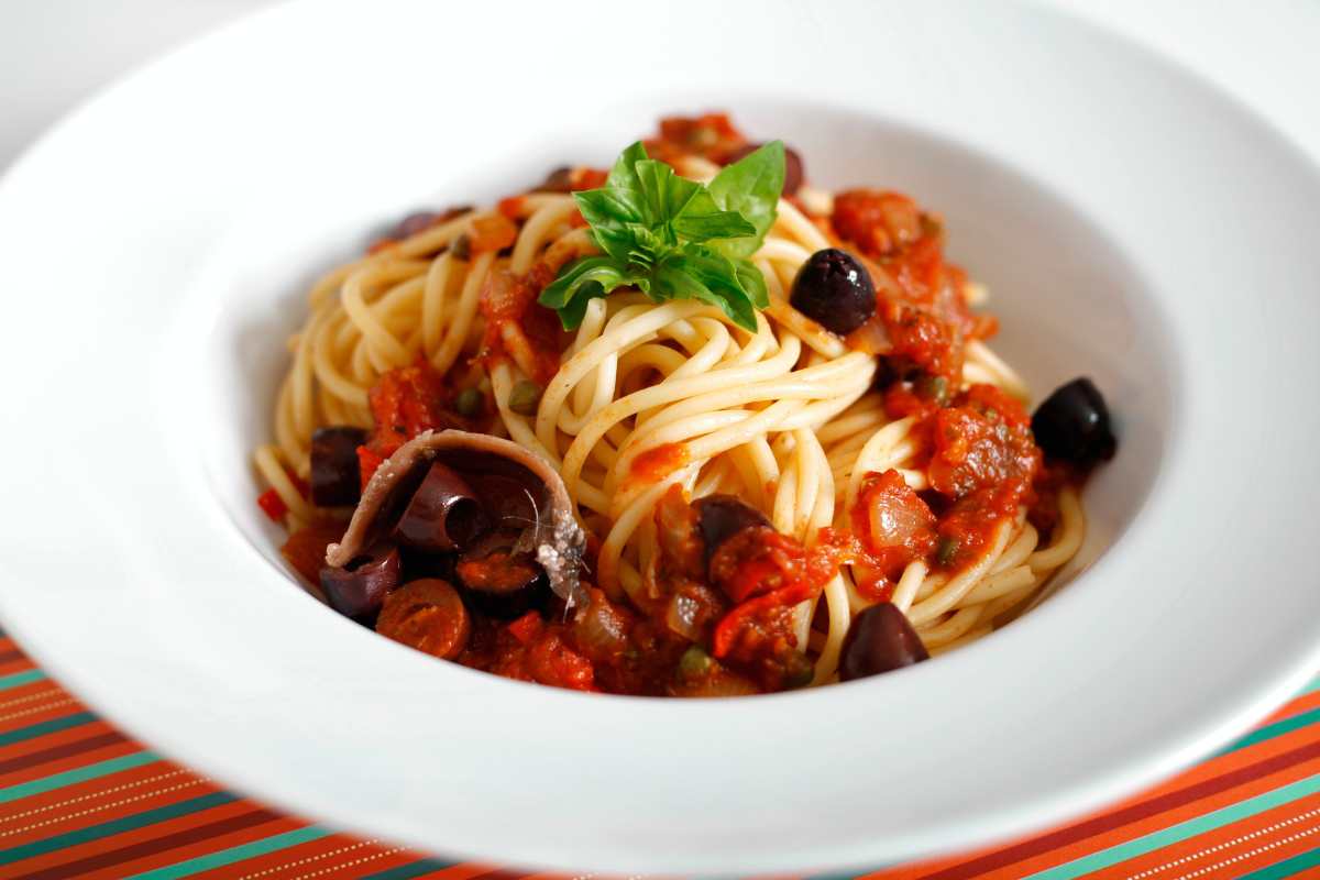 spaghetti alla puttanesca in un piatto bianco