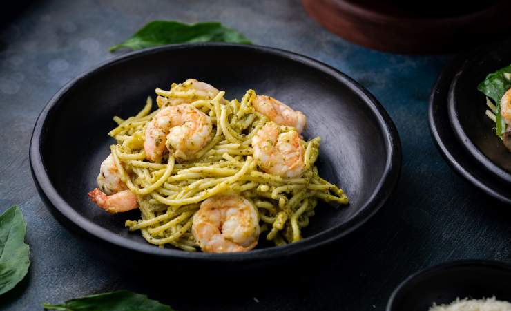 pasta ai gamberetti con pesto di zucchine in piatto nero