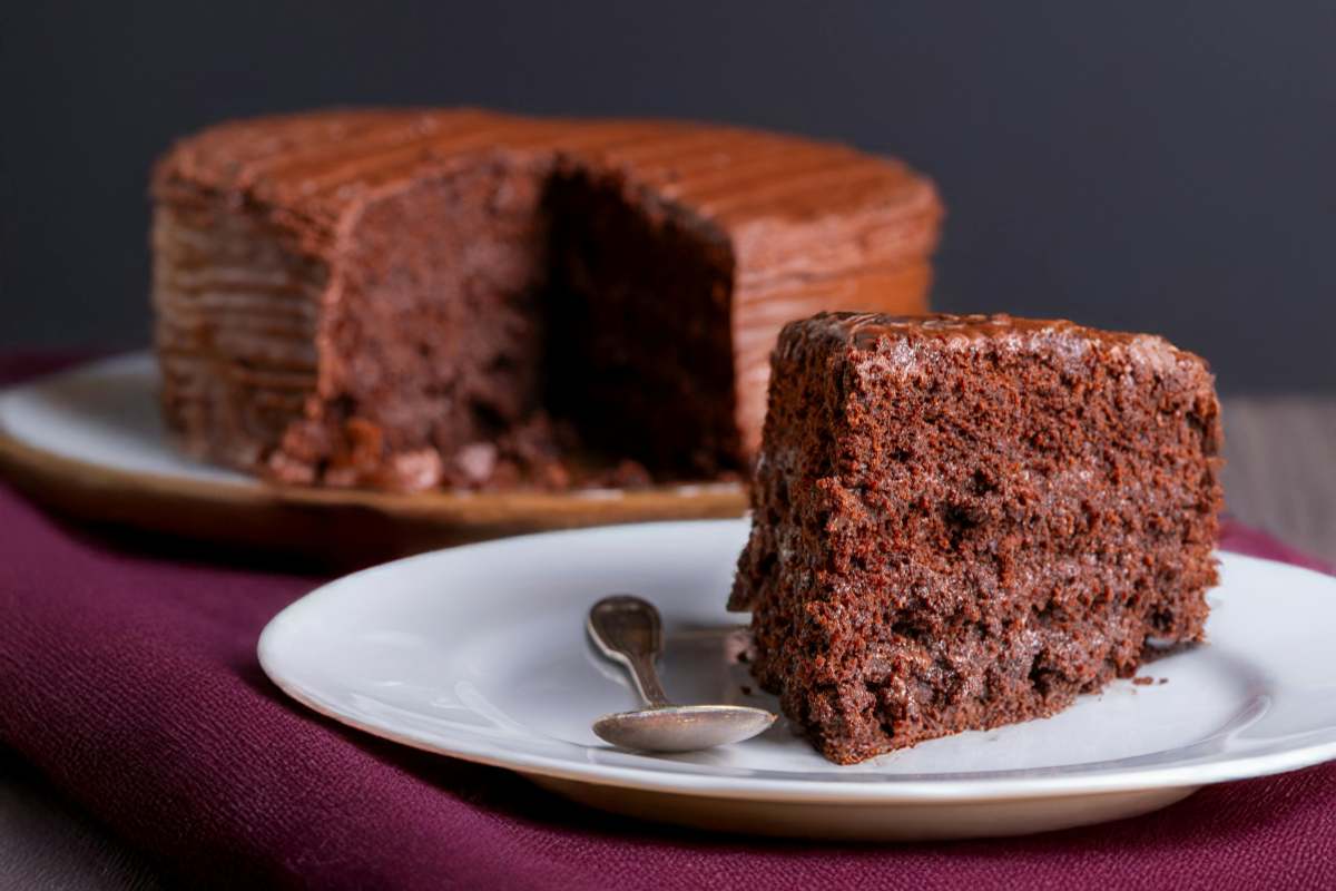 torta al cacao tagliata in un piattino con accanto un cucchiaino