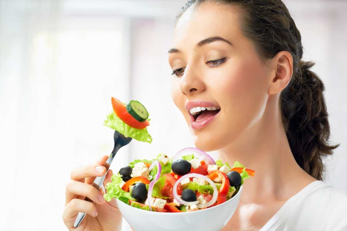 Donna che mangia una ciotola di insalata