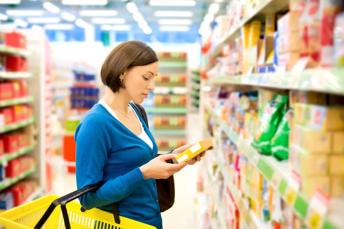 Donna con prodotto in mano al supermercato