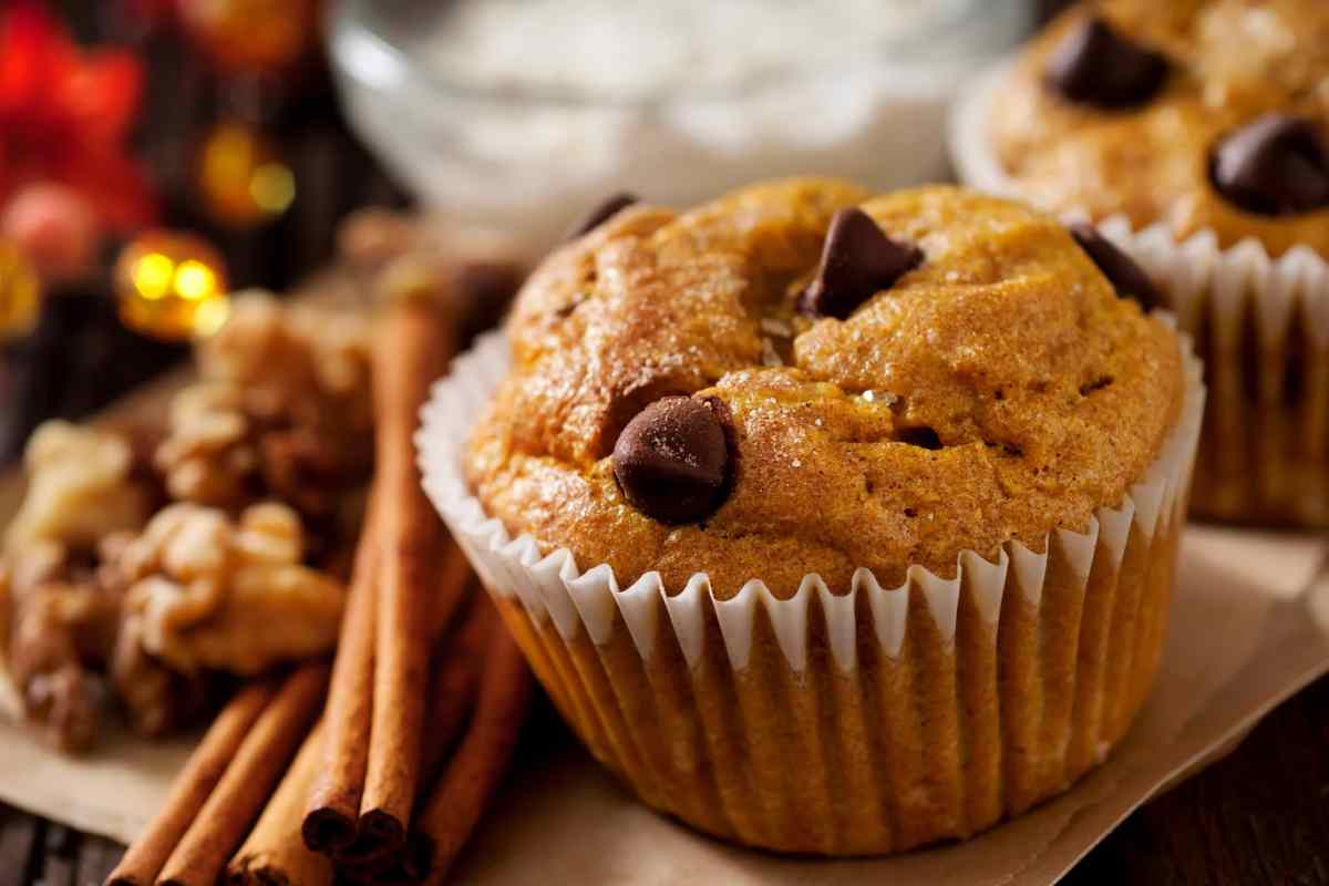 Un muffin con gocce di cioccolato e stecche di cannella